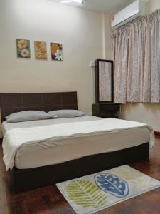 a bedroom with a large bed with a white bedspread at Rafflesia Two Bedroom Pool View in Kampong Tanah Merah