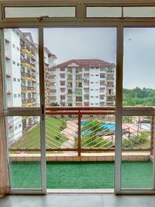 uma vista da janela de um edifício em Rafflesia Two Bedroom Pool View em Kampong Tanah Merah