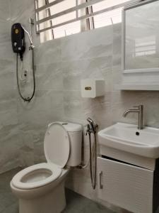 y baño con aseo y lavamanos. en Rafflesia Two Bedroom Pool View en Kampong Tanah Merah