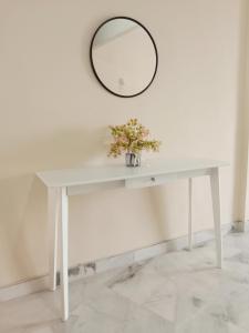 a white table with a mirror on the wall at Rafflesia Two Bedroom Pool View in Kampong Tanah Merah
