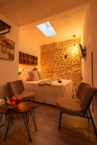 ein Hotelzimmer mit einem Bett, 2 Stühlen und einem Tisch in der Unterkunft Alojamientos Plaza de España in Medina-Sidonia