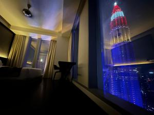 a room with a view of the empire state building at night at Tropicana The Residence Klcc By Sky World in Kuala Lumpur
