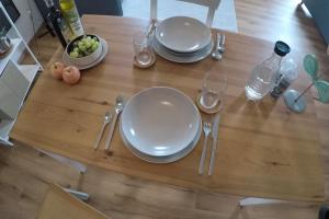 a wooden table with plates and forks and spoons at Studio-Apartementwohnung in Kassel