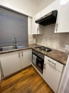a kitchen with a sink and a stove at Edgware Road Large Ground Floor Studio in London