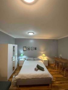 a bedroom with a bed with two tables and two lamps at Edgware Road Large Ground Floor Studio in London