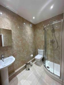 a bathroom with a shower and a toilet and a sink at Edgware Road Large Ground Floor Studio in London