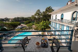 een tafel op een balkon met uitzicht op een zwembad bij Hotel Mercedes in Hossegor