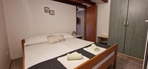 a bedroom with a bed with two towels on it at Apartmani Dutković in Vrboska