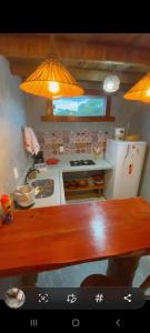 a kitchen with a wooden table and a counter top at Chale Flat pousada do vini in Corumbau