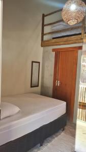 a bedroom with a bunk bed and a wooden door at Chale Flat pousada do vini in Corumbau