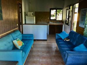 ein Wohnzimmer mit zwei blauen Sofas und einer Katze in der Unterkunft Faré Luciana Moorea in Moorea