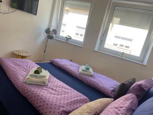 a bedroom with purple pillows on a bed with windows at Anna in Livno