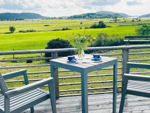 una mesa y 2 sillas en una terraza con un campo en Holiday home kode VI en Kode