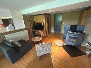 a living room with a couch and a stove at Au mont des Brumes in Stoumont