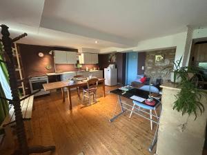 cocina y sala de estar con mesa y sillas en Au mont des Brumes, en Stoumont
