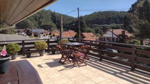 a patio with a table and chairs on a balcony at Apartamento Brumone in Monte Verde