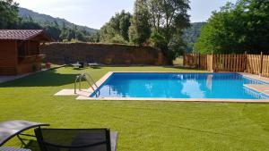 una gran piscina en un patio con césped en Masia Can Orta, en Sant Feliu de Buixalleu