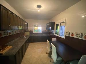 a large kitchen with a long counter and chairs at Sea house in Nador