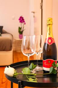 阿爾馬達的住宿－Golden Place - Cacilhas，桌子上放有一瓶香槟和两杯酒杯