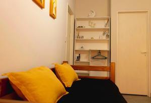 um quarto com uma cama com almofadas amarelas e uma prateleira em LOS GURISES em Villa Elisa