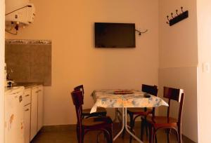 cocina con mesa con sillas y TV en la pared en LOS GURISES en Villa Elisa