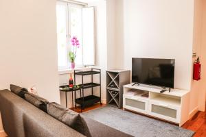 a living room with a couch and a flat screen tv at Golden Place - Cacilhas in Almada