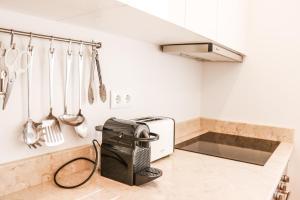 a kitchen with a counter with a microwave and utensils at Golden Place - Cacilhas in Almada