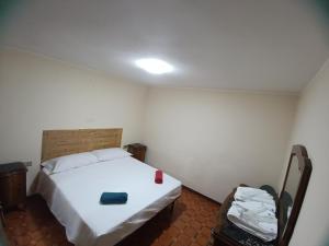 een slaapkamer met een wit bed en een houten hoofdeinde bij I 3 Moschettoni in Valbrona