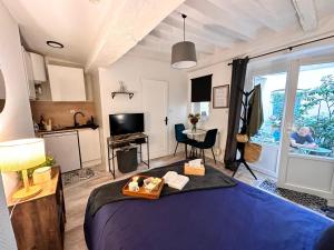 a bedroom with a bed and a kitchen and a table at Beau studio et sa terrasse quartier historique in Moulins