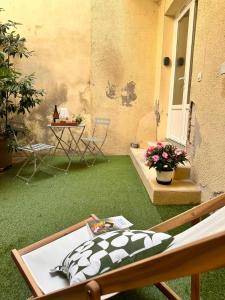 d'une terrasse avec de la pelouse verte, une table et des chaises. dans l'établissement Beau studio et sa terrasse quartier historique, à Moulins