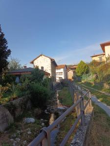 a bridge over a stream with houses in the background at I 3 Moschettoni in Valbrona