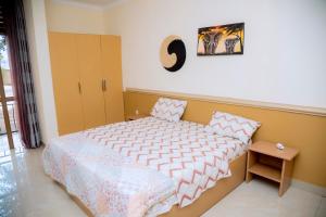a small bedroom with a bed and a table at Cosy Hidden Gem in Kigali