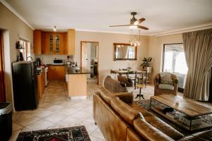 a living room and kitchen with a couch and a table at Breathe Accommodation in Oudtshoorn