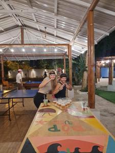 two women standing in front of a ping pong table at Pop House in Montañita