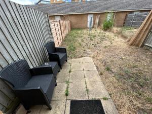 two black chairs sitting on a patio in a backyard at Mannys Nice & Cozy Rooms in Thamesmead