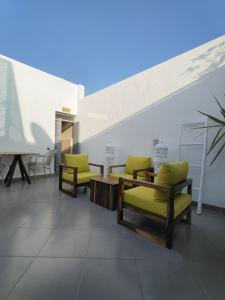 een lobby met stoelen en tafels en een trap bij Riad L'Arganier in Marrakesh