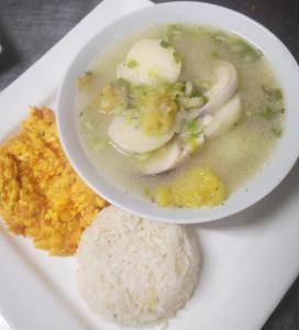 un plato de comida con un tazón de sopa y arroz en The Frailejon House, en Bogotá