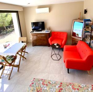 a living room with a red couch and a table at LE SEPT charmant studio aux portes des calanques in Cassis