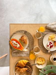 uma mesa com pratos de pastelaria e chávenas de sumo de laranja em Casa do Rio em Leiria