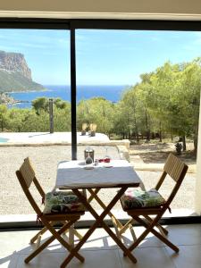 a table and two chairs in front of a window at LE SEPT charmant studio aux portes des calanques in Cassis