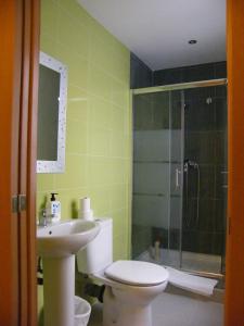 a bathroom with a toilet and a sink and a shower at Pensi&oacute;n Corona in Zaragoza