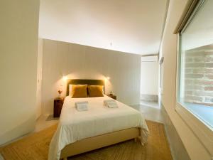 a bedroom with a large bed and a large window at Casa do Rio in Leiria