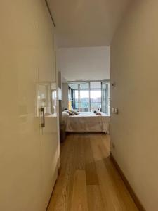 un corridoio con una camera da letto e un letto in una stanza di EuroSky Prestige Apartment ROMA EUR a Roma