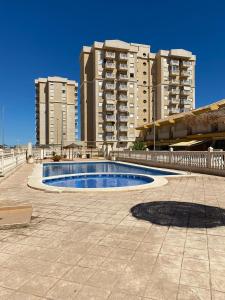 a swimming pool in front of some tall buildings at CASA ALMA Playa Paraiso Estupenda vivienda cerca de la Playa in Cartagena