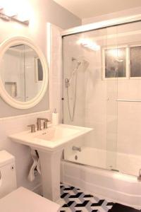 ein weißes Bad mit einem Waschbecken und einer Dusche in der Unterkunft Newly Furnished Pool House in Los Angeles