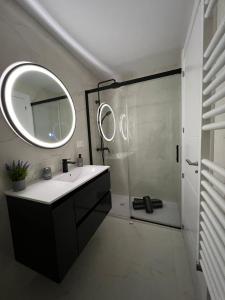 a bathroom with a sink and a shower with a mirror at El Molino in Albacete