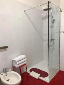 La salle de bains est pourvue d'une douche en verre et d'un lavabo. dans l'établissement Casa Clementi, à Barolo