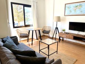 a living room with a couch and a table at Weybeach4 -sea frontline,plaza view,little terrace in La Santa