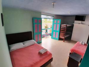 1 dormitorio con 1 cama, 2 puertas y mesa en Hostal Johnnier, en Salento