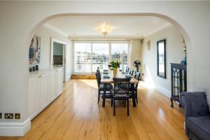 a dining room with a table and chairs at Kensington Skyline Penthouse in London